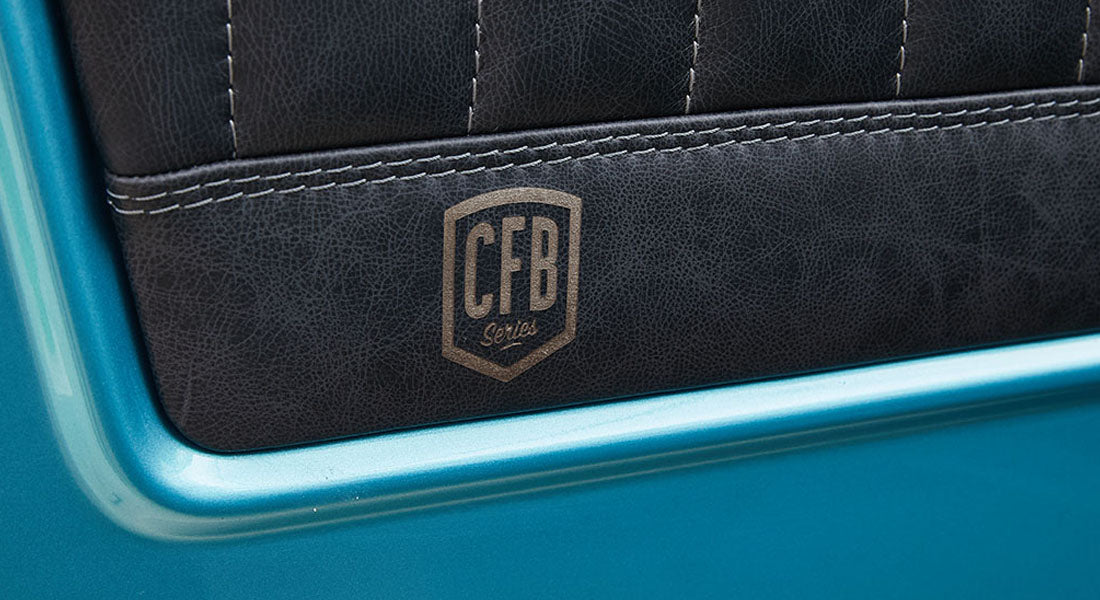 Close-up of textured black leather door panel with CFB Series laser-etched logo in a Classic Ford Bronco