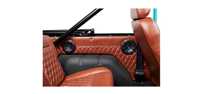 Interior view of Classic Ford Bronco brown leather seats and quilted door panel with black speaker grilles