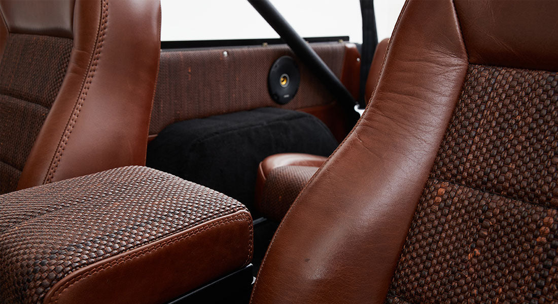 Interior view of brown and patterned fabric front seats inside Classic Ford Bronco