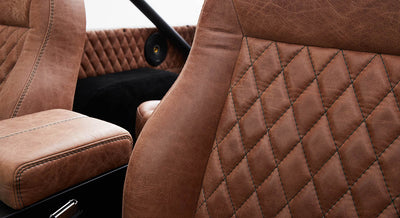 Close-up of quilted brown leather seat and door panel interior in Classic Ford Bronco