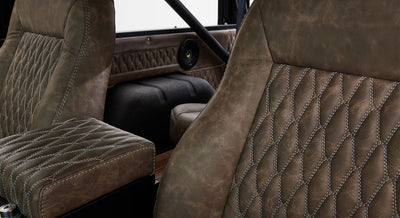 Quilted brown leather upholstery with white stitching on Classic Ford Bronco passenger seat and interior side panel