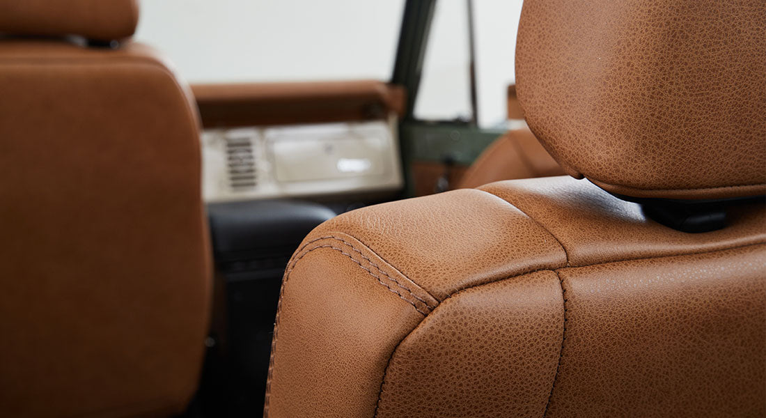 Close-up of brown leather seat stitching and texture inside Classic Ford Bronco