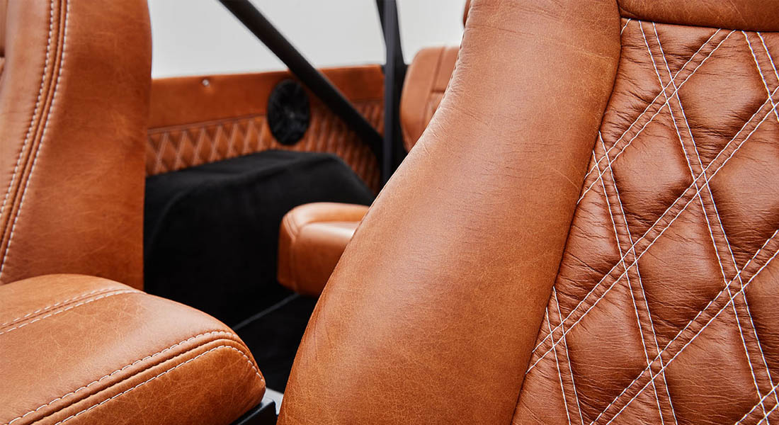 Brown leather seat close-up showing diamond-pattern stitch detail inside a Classic Ford Bronco.