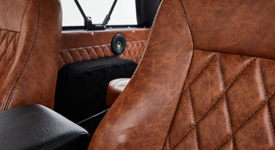 Close-up of vintage brown leather seats and speaker with quilted pattern interior