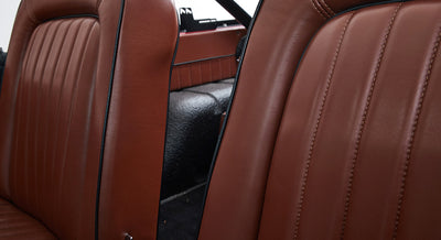 Close-up of brown leather seats with black piping inside a Classic Ford Bronco