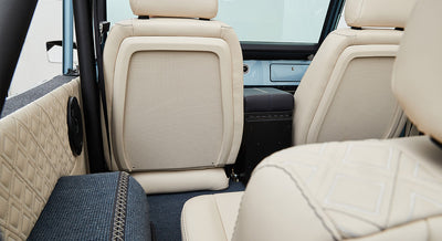 Rear seatback and quilted beige door panel inside a Classic Ford Bronco