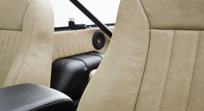 Beige leather seats and interior panel of a Classic Ford Bronco with black speaker