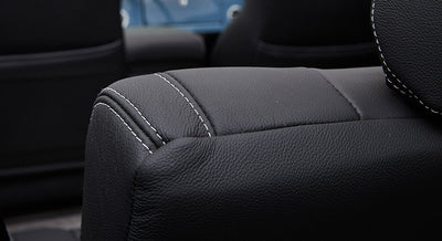 Close-up of black leather upholstery with white stitching inside classic Ford Bronco