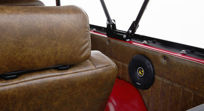 Brown leather rear seat backrest and black speaker mounted on interior panel with red Classic Ford Bronco body