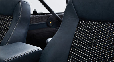 Interior of Classic Ford Bronco showing blue leather seats with patterned fabric inserts