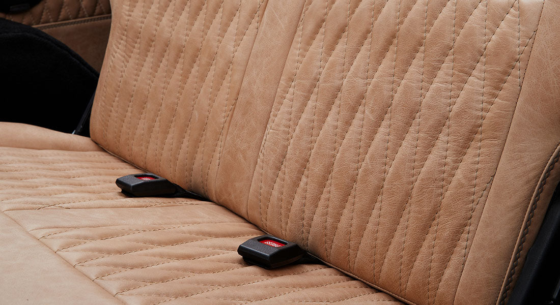 Close-up of tan quilted and sewn leather seat upholstery inside a Classic Ford Bronco