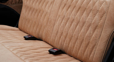 Close-up of tan quilted and sewn leather seat upholstery inside a Classic Ford Bronco