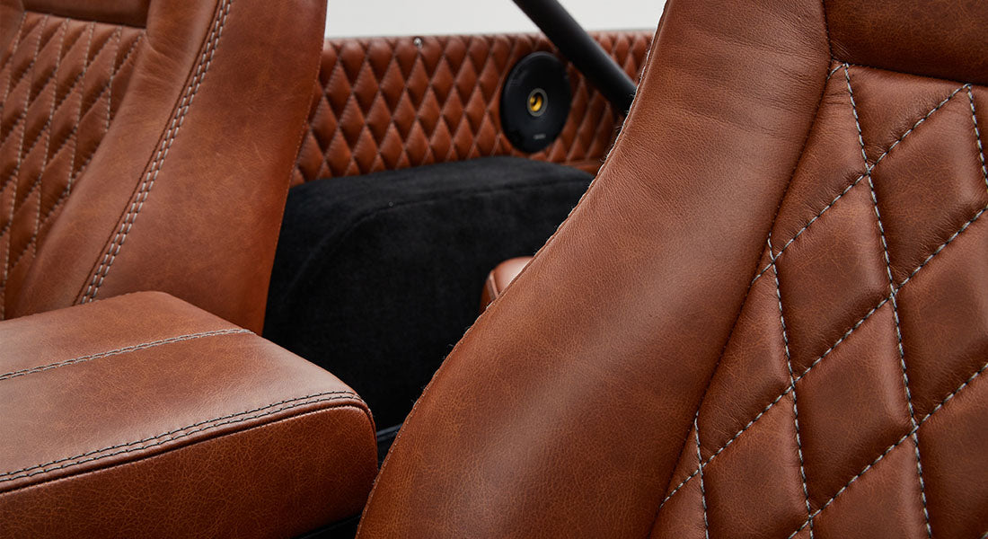 Close-up of brown quilted leather seats and accent speaker inside a Classic Ford Bronco