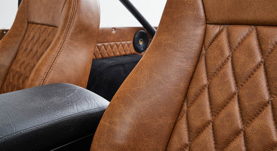 Close-up of brown leather seat and black armrest inside Classic Ford Bronco