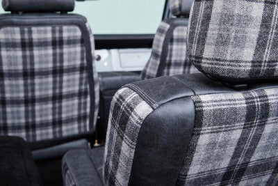 Plaid fabric and black leather upholstery on Classic Ford Bronco seat backs