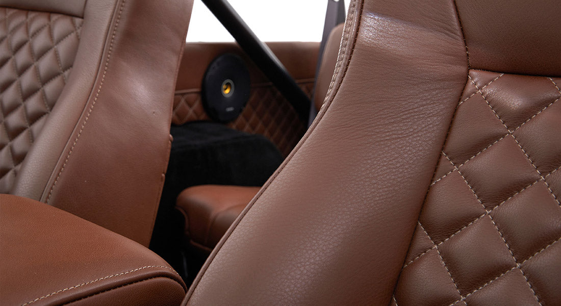 Close-up of brown, diamond-stitched leather seat upholstery inside Classic Ford Bronco.