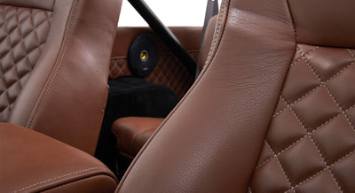 Close-up of brown, diamond-stitched leather seat upholstery inside Classic Ford Bronco.
