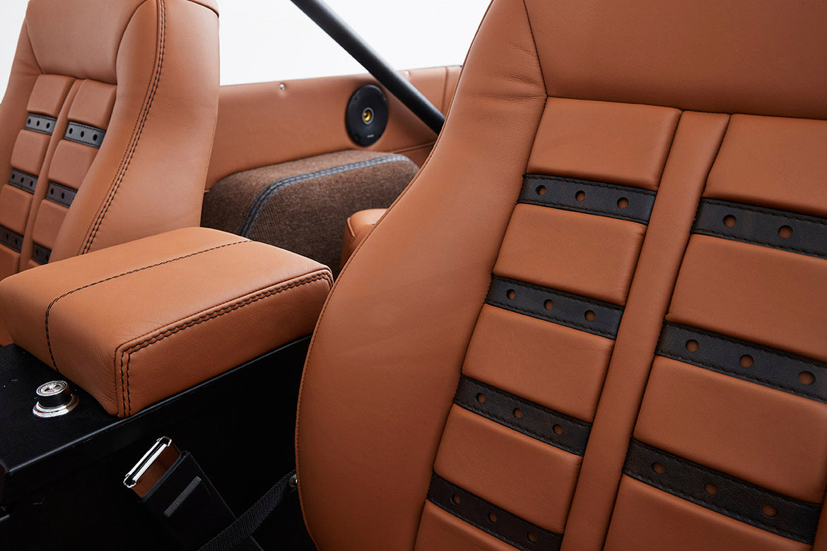 Close-up of tan and black leather upholstery on Classic Ford Bronco front seats and armrest
