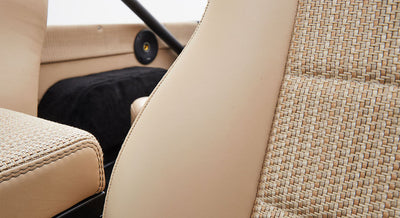 Beige woven upholstery fabric and vinyl seat backs inside vehicle