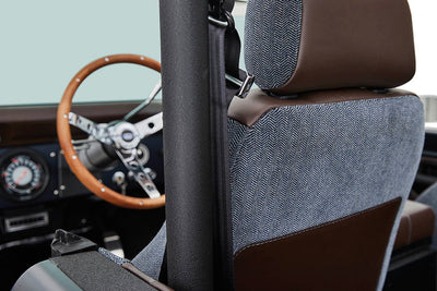 Close-up of Classic Ford Bronco driver's seat with brown leather and patterned fabric