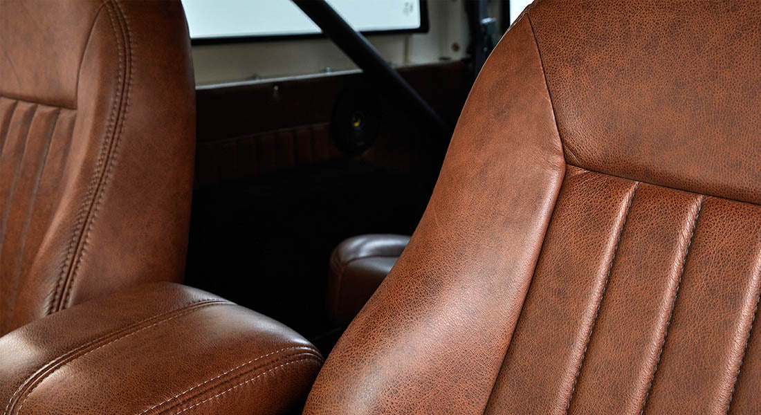Brown leather seats and black roll cage inside Classic Ford Bronco interior
