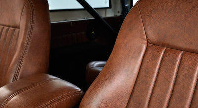 Brown leather seats and black roll cage inside Classic Ford Bronco interior