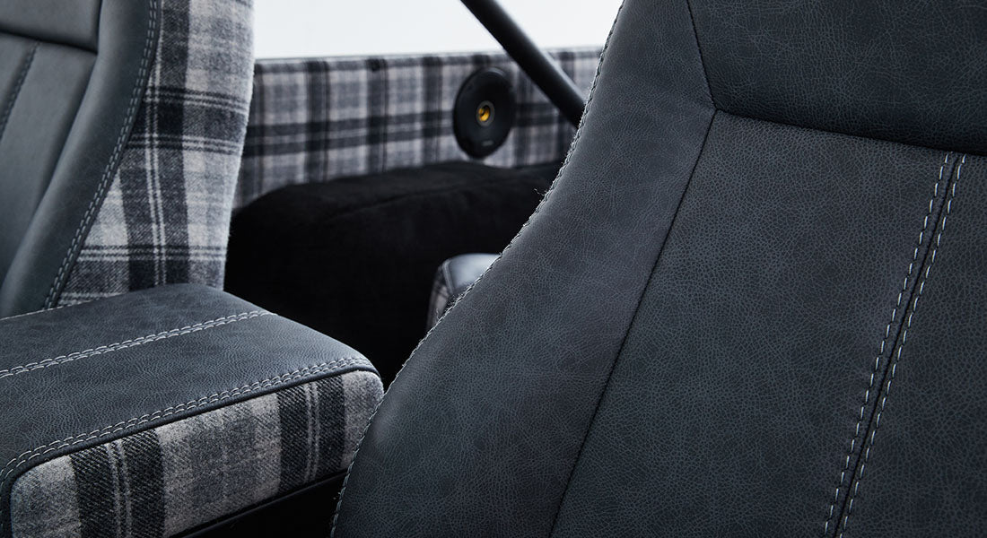 Close-up of black leather and plaid fabric car seats in a Classic Ford Bronco