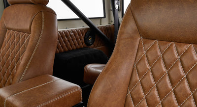 Brown leather seats with diamond stitching and roll cage bars inside Classic Ford Bronco