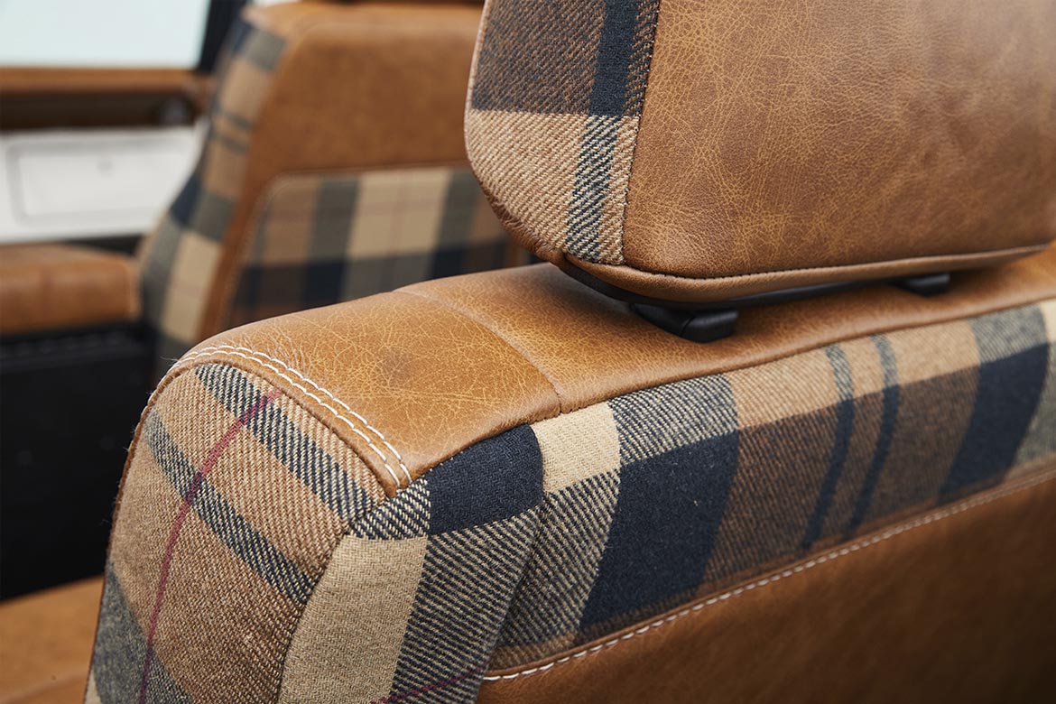 Close-up of brown leather and plaid fabric seat detail in Classic Ford Bronco
