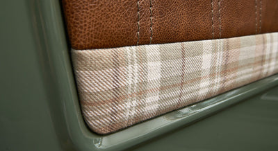 Plaid fabric and brown leather trim on interior door panel of Classic Ford Bronco