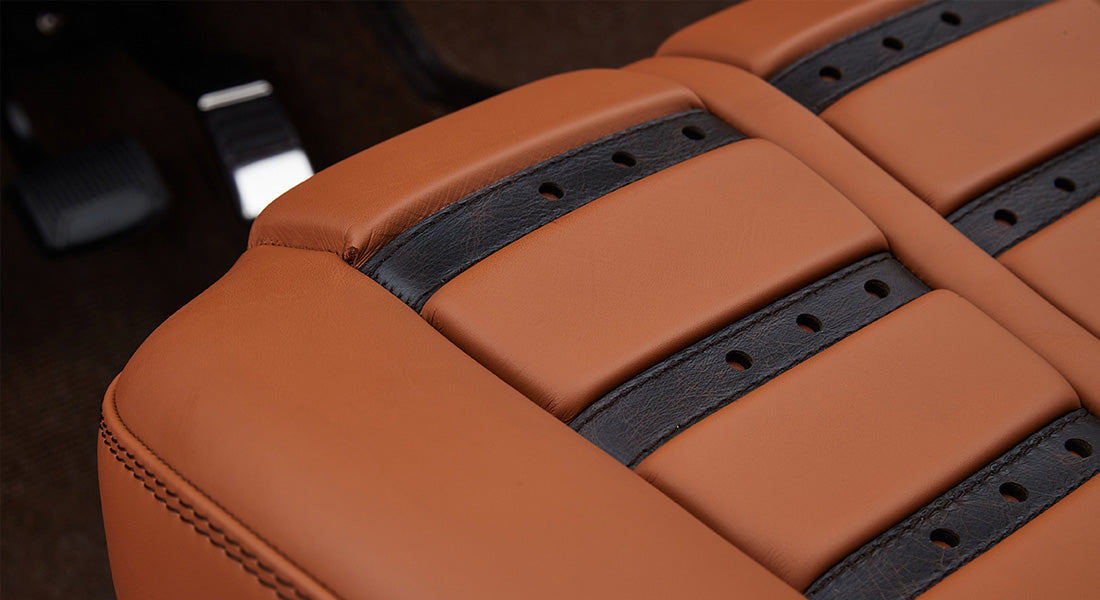 Close-up of tan leather upholstery with embossed CFB Series logo on Classic Ford Bronco interior