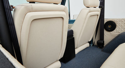 Beige leather rear seats and quilted door panel inside a Classic Ford Bronco