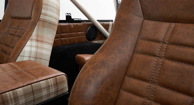 Close-up of brown leather and plaid fabric seats inside Classic Ford Bronco