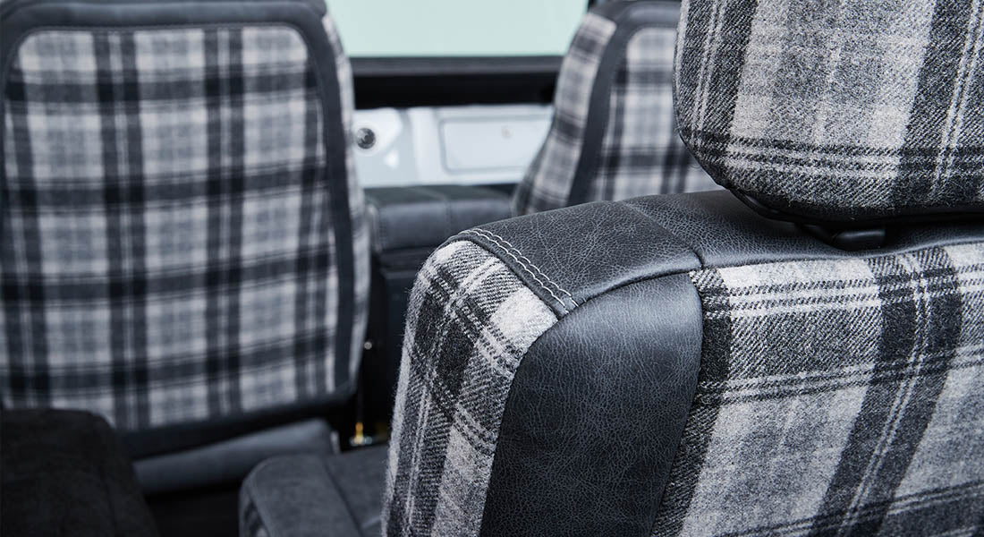 Plaid fabric and leather front seats inside a Classic Ford Bronco