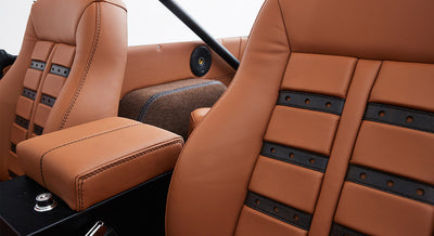 Close-up of tan and black leather upholstery on Classic Ford Bronco front seats and armrest