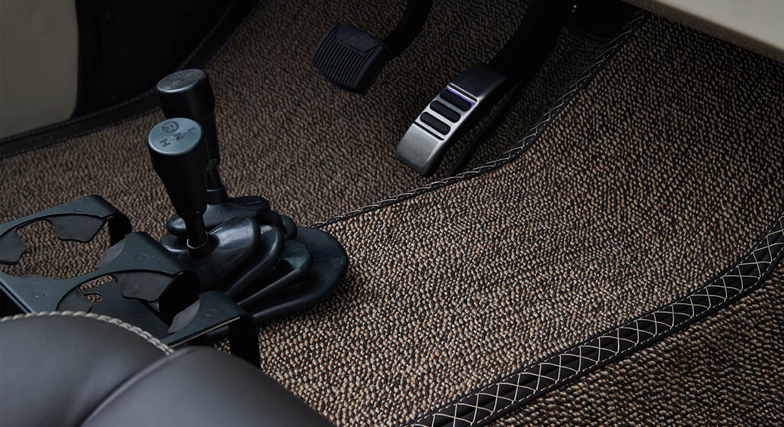 Footwell showing clutch and brake pedals and textured floor mat inside Classic Ford Bronco