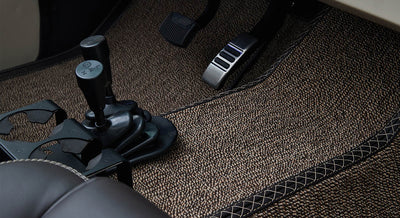 Footwell showing clutch and brake pedals and textured floor mat inside Classic Ford Bronco