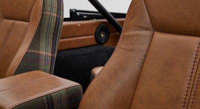 Close-up of Classic Ford Bronco front seats with brown leather and plaid fabric details