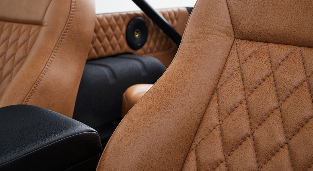 Classic Ford Bronco interior with tan leather seats and quilted door panel detail