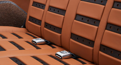 Tan and black leather rear seats with seatbelt buckles in Classic Ford Bronco interior