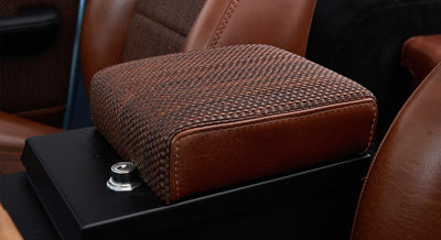 Pair of black round speakers set in woven brown fabric panel inside Classic Ford Bronco