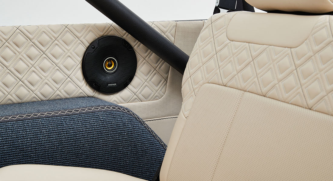 Close-up of beige quilted leather and fabric upholstery with speaker on Classic Ford Bronco door