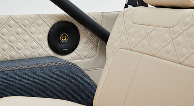 Close-up of beige quilted leather and fabric upholstery with speaker on Classic Ford Bronco door