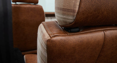 Detailed view of brown leather and plaid fabric seat corner in Classic Ford Bronco