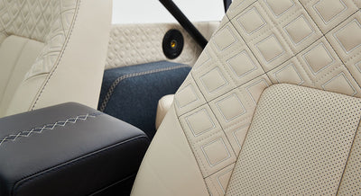 Quilted beige leather seat with diamond pattern and blue woven carpet inside Classic Ford Bronco