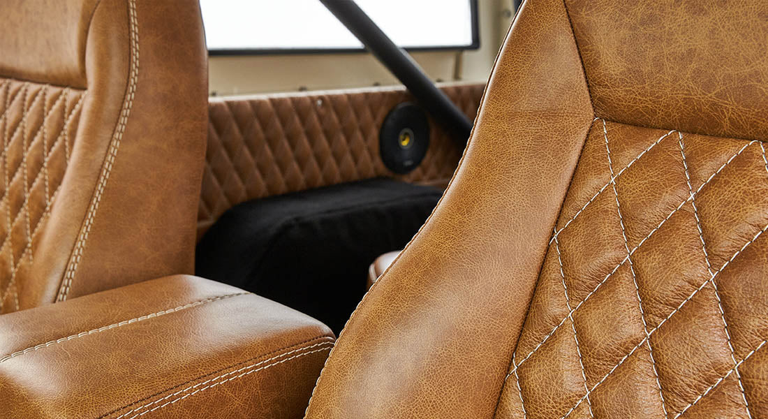 Brown leather driver's seat and armrest with white stitching in Classic Ford Bronco interior
