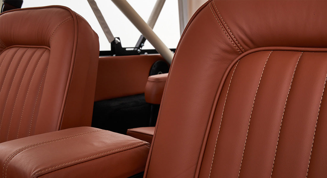 Close-up of brown leather seats and center armrest inside Classic Ford Bronco