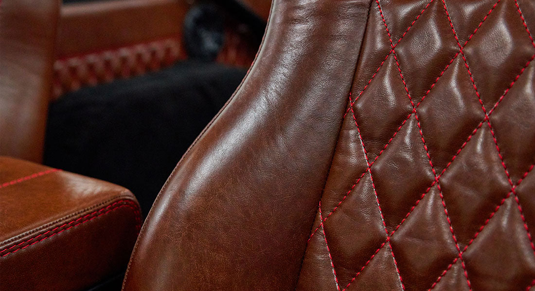 Close-up of brown leather seats with red stitching in Classic Ford Bronco interior