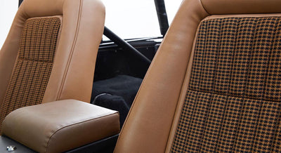 Two brown and plaid front seats inside a Classic Ford Bronco