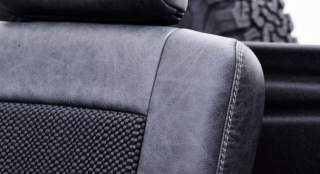 Close-up of black and gray textured upholstery with visible stitching on Classic Ford Bronco seat.